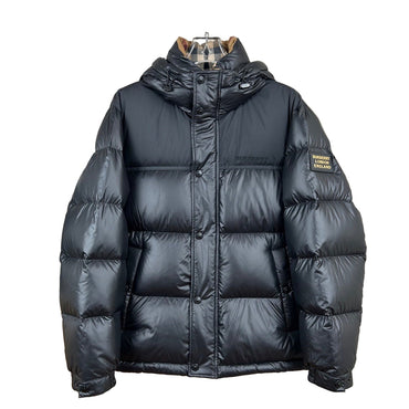 Black puffer jacket on a mannequin against a neutral wall.