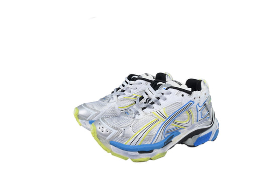 White sneakers with blue and yellow accents next to box on a white background