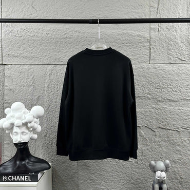 Black sweatshirt hanging on a rack against a textured wall