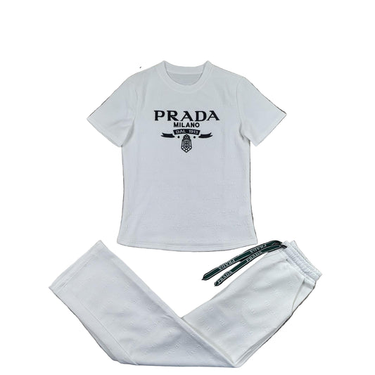 White t-shirt with graphic and matching pants on a gray surface