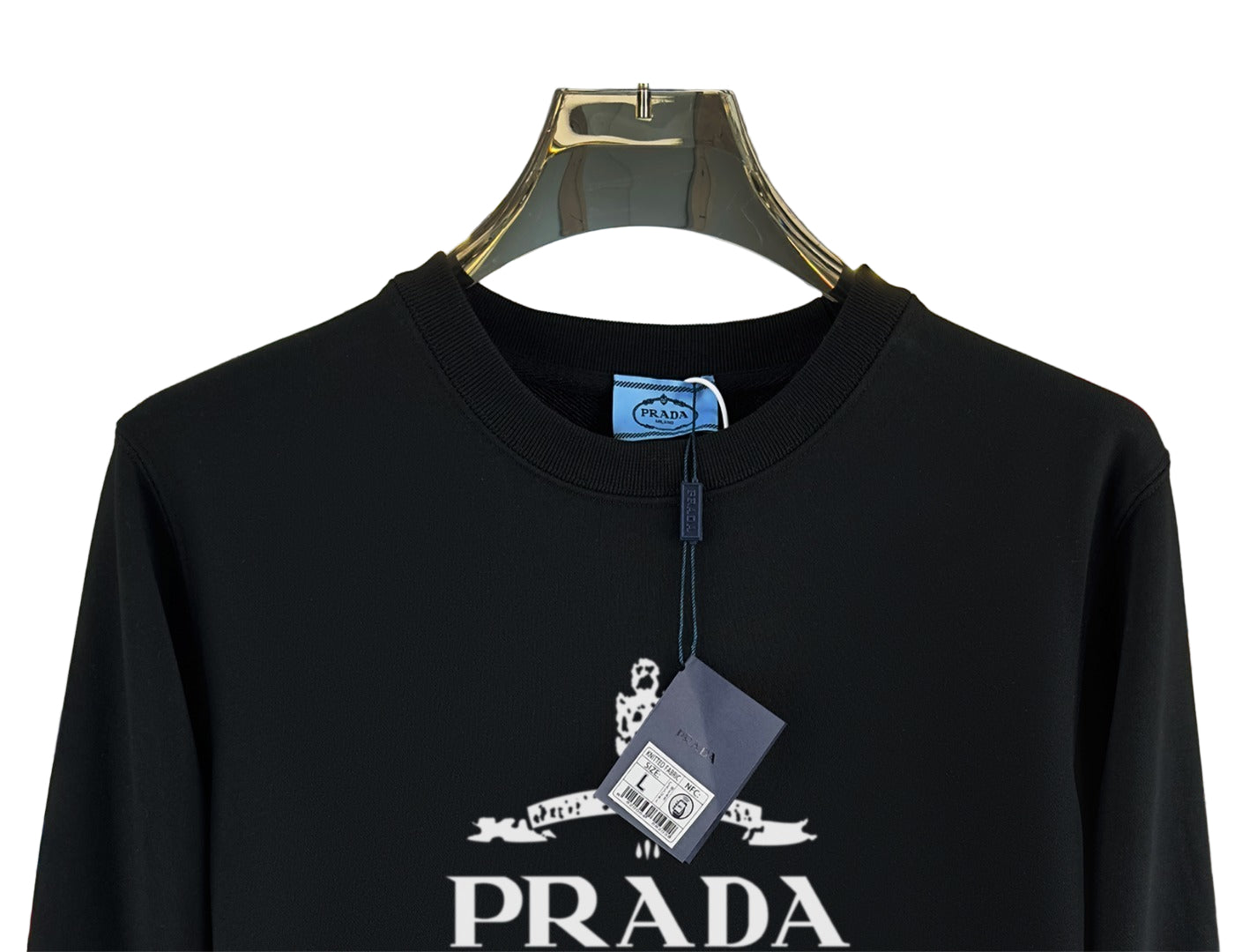 Black sweatshirt on a hanger with a blurred store background