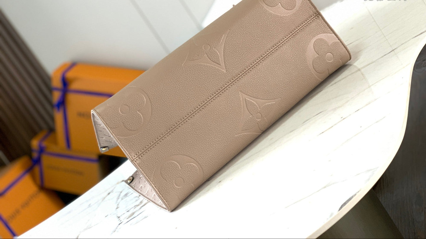 OnTheGo MM tote bag in Tourterelle (taupe) Monogram Empreinte leather bottom