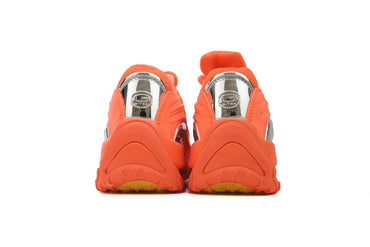 Pair of orange sneakers with a brand graphic on a white background