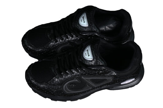 Black sneakers with 'gra[hic on a black grid background