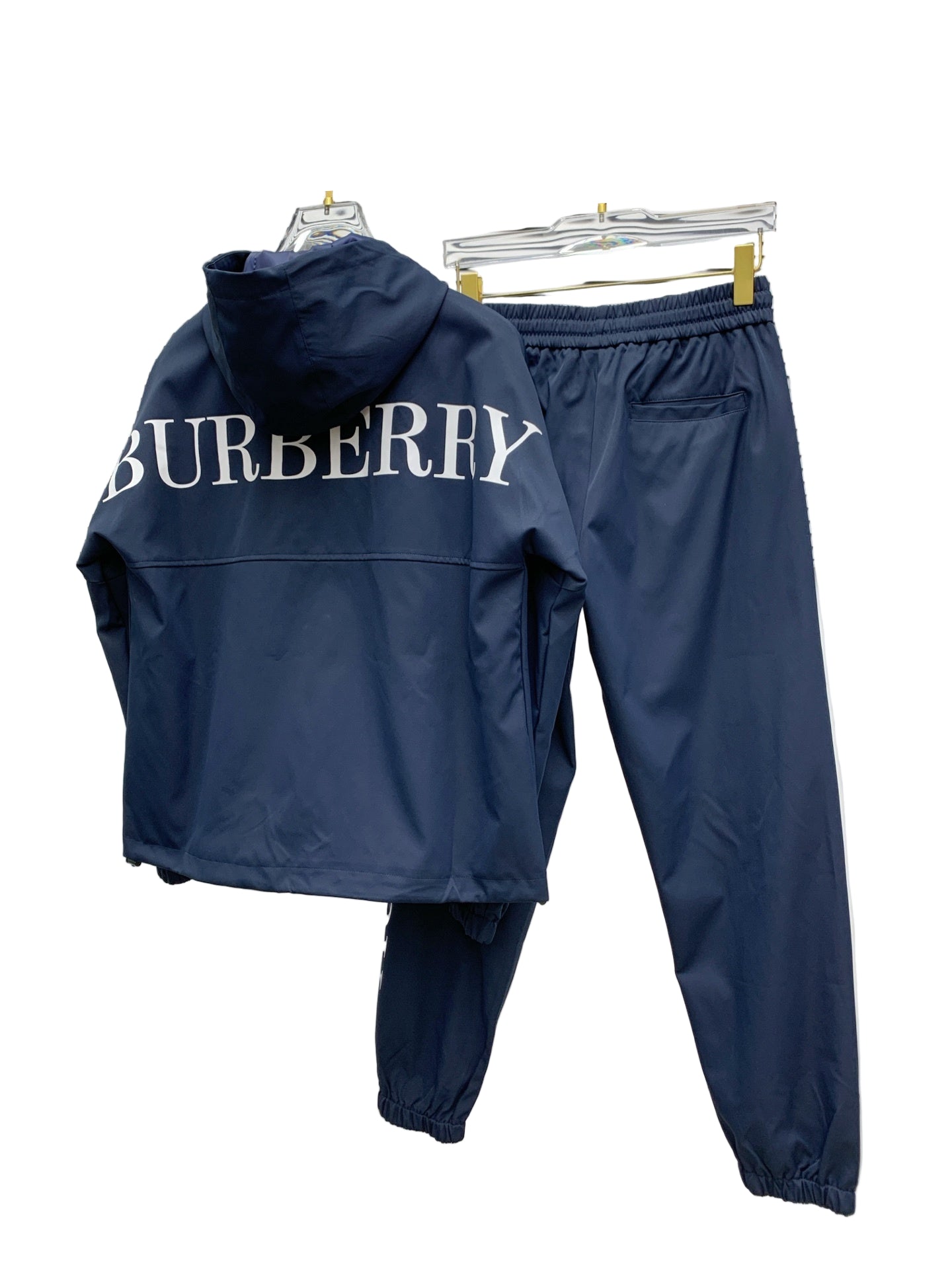 Navy  tracksuit hanging against a white wall.