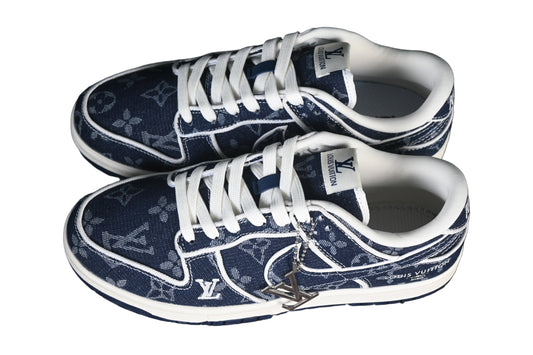 Pair of blue sneakers with white laces on a black mesh background