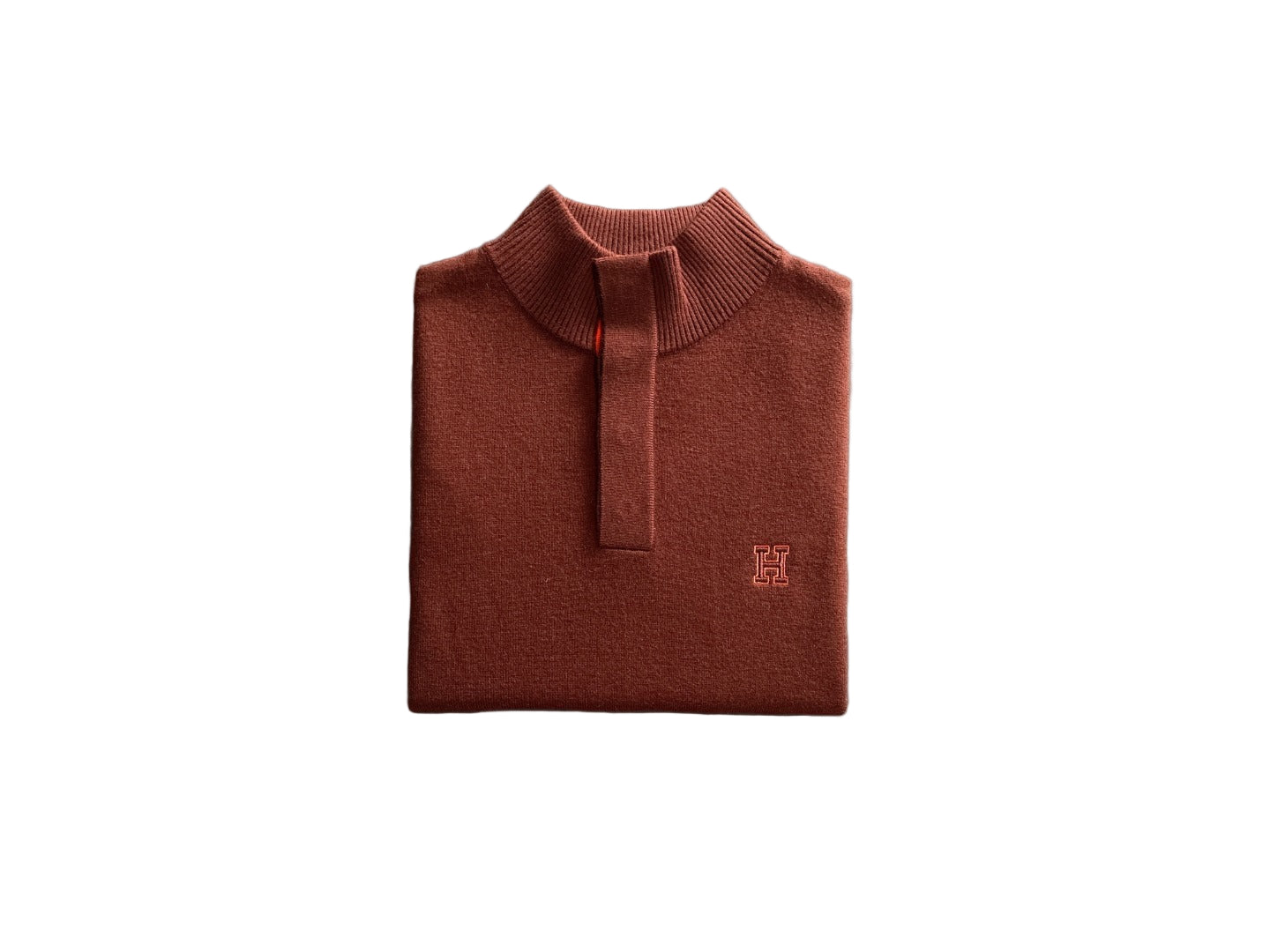 Folded brown polo shirt on a dark surface with a textured gray area.