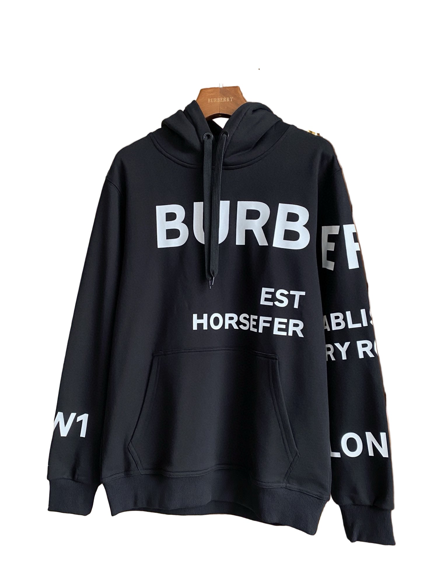 Black hoodie with graphic on a hanger against a neutral background