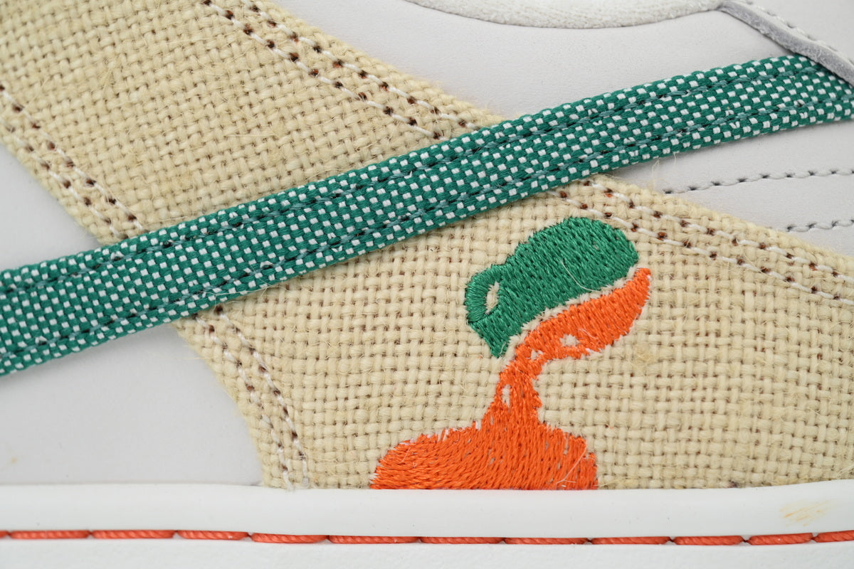 Cream and green canvas low-top sneaker with white leather panels, lace-up closure, and rubber outsole displayed from front and side angles.