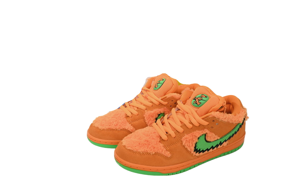 Orange sneakers with green accents next to a colorful box on a white background