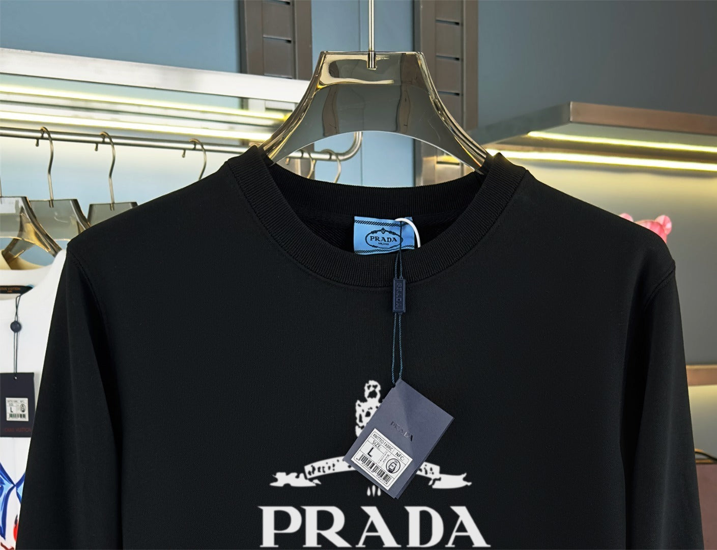 Black sweatshirt on a hanger with a blurred store background