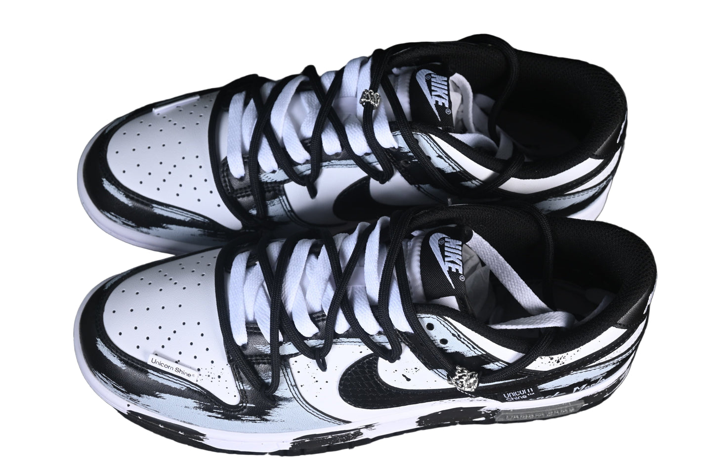 Black and white sneakers on a black grid background