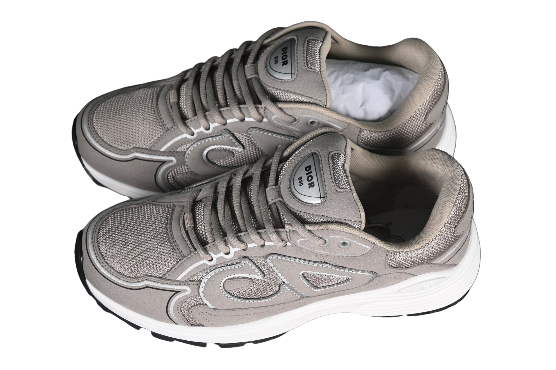 Pair of gray sneakers on a black grid background