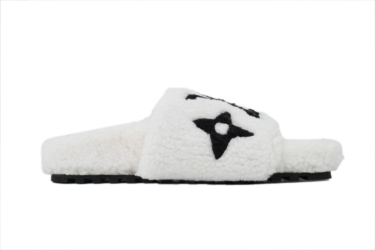 White fuzzy slide sandal with a black star graphic  on a white background