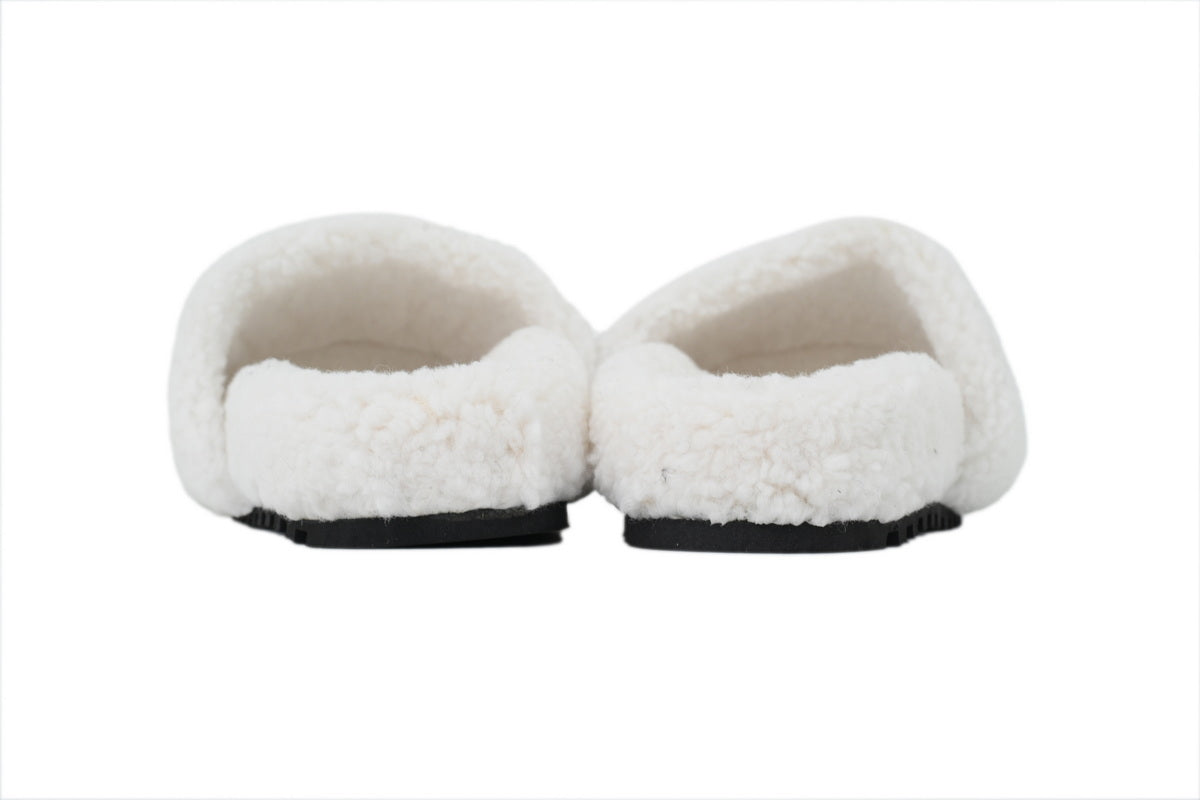 Pair of white slippers with black soles on a white background