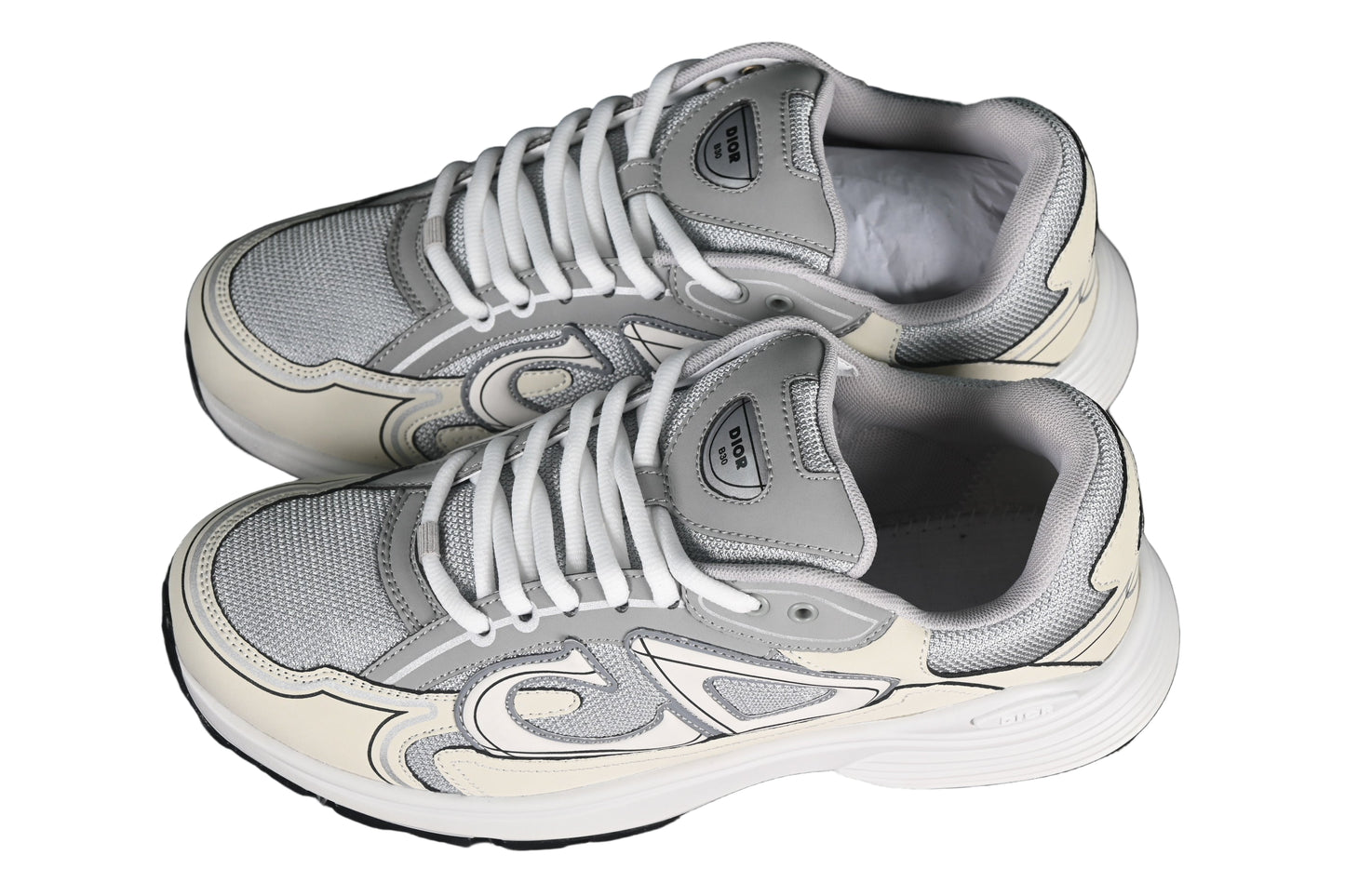 Pair of gray sneakers on a black grid background