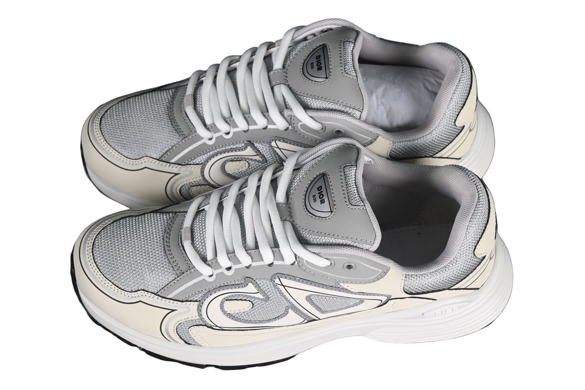 Pair of gray sneakers on a black grid background