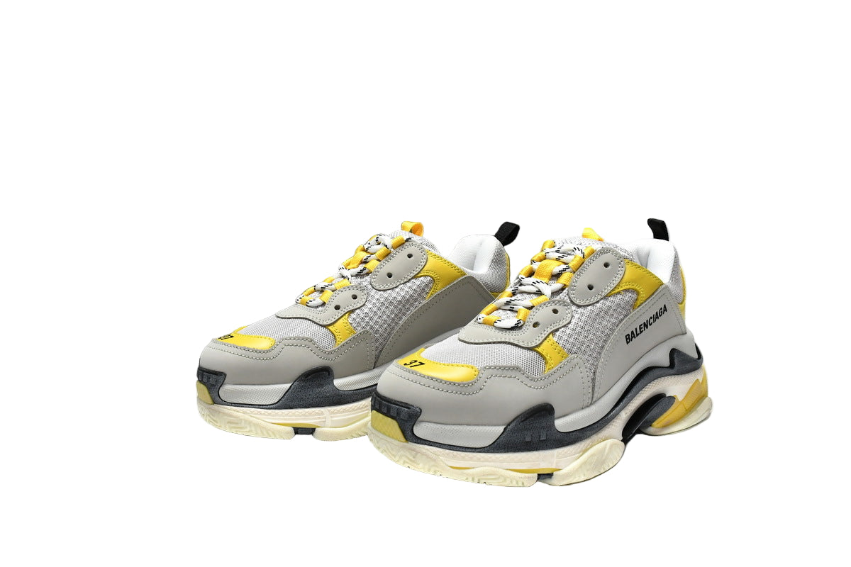 Gray and yellow  sneakers with a matching box on a white background