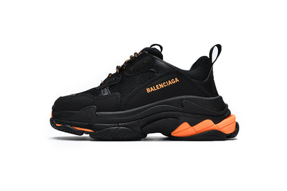 Black sneaker with orange accents on a white background