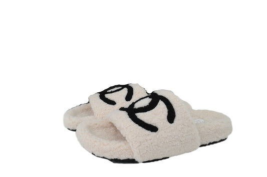 Beige CC slippers with graphic  on a white background