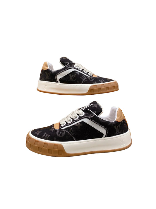 Low-top sneakers crafted from black suede calf leather, inspired by early-2000s footwear proportions. This design features wide textile laces for a bold profile, an inclined embroidered initials detail on the tongue, and a chunky rubber outsole.