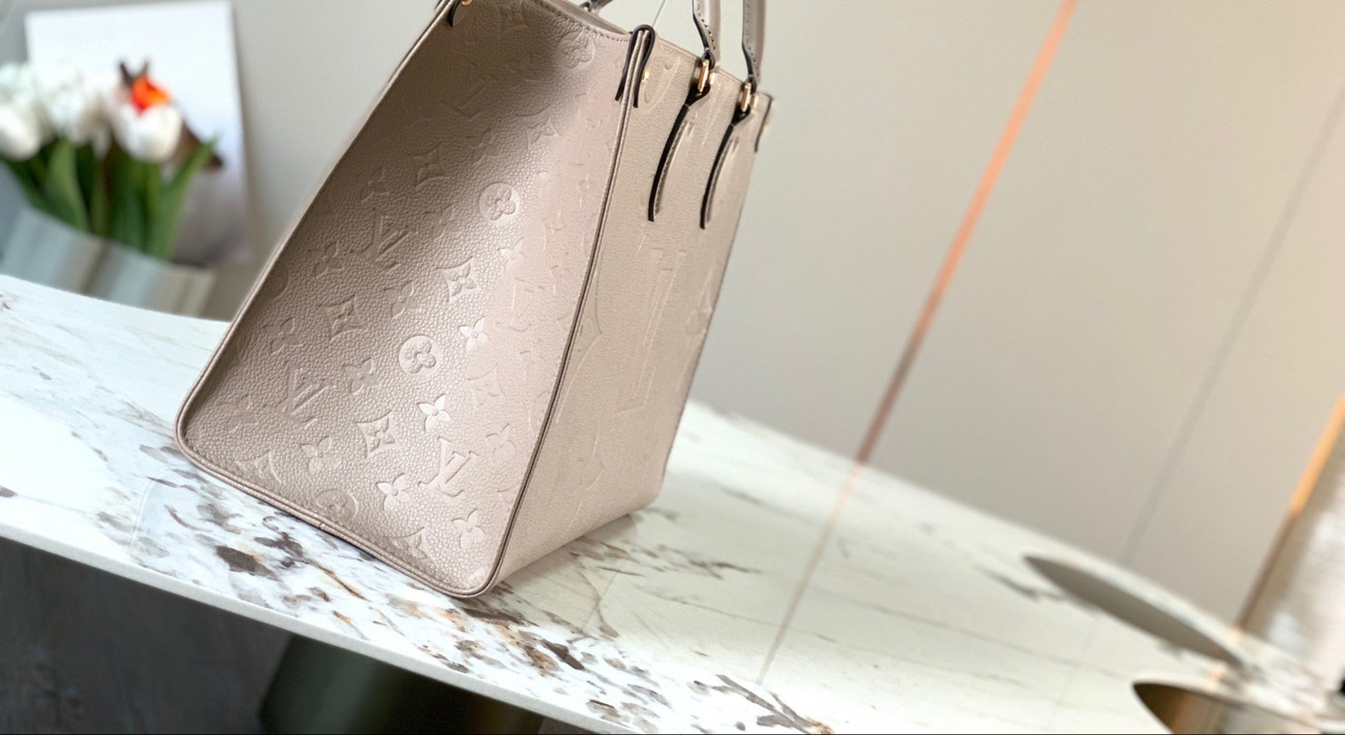 OnTheGo MM tote bag in Tourterelle (taupe) Monogram Empreinte leather side