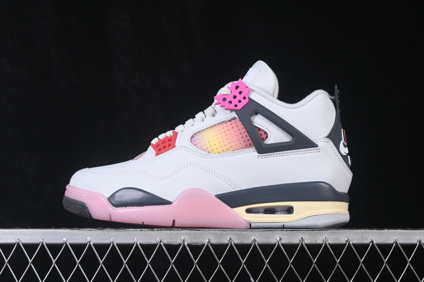 White retro basketball sneaker with pink accents, charcoal support panels, breathable mesh inserts, lace-up closure, and rubber outsole.
