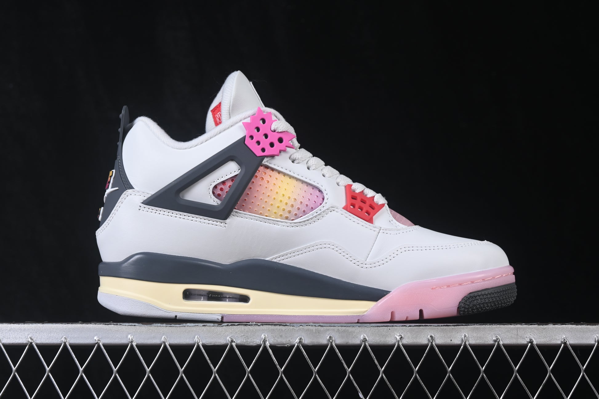 White retro basketball sneaker with pink accents, charcoal support panels, breathable mesh inserts, lace-up closure, and rubber outsole.