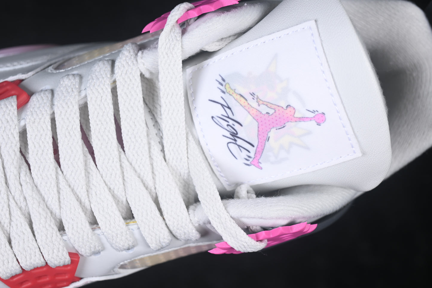 White retro basketball sneaker with pink accents, charcoal support panels, breathable mesh inserts, lace-up closure, and rubber outsole.