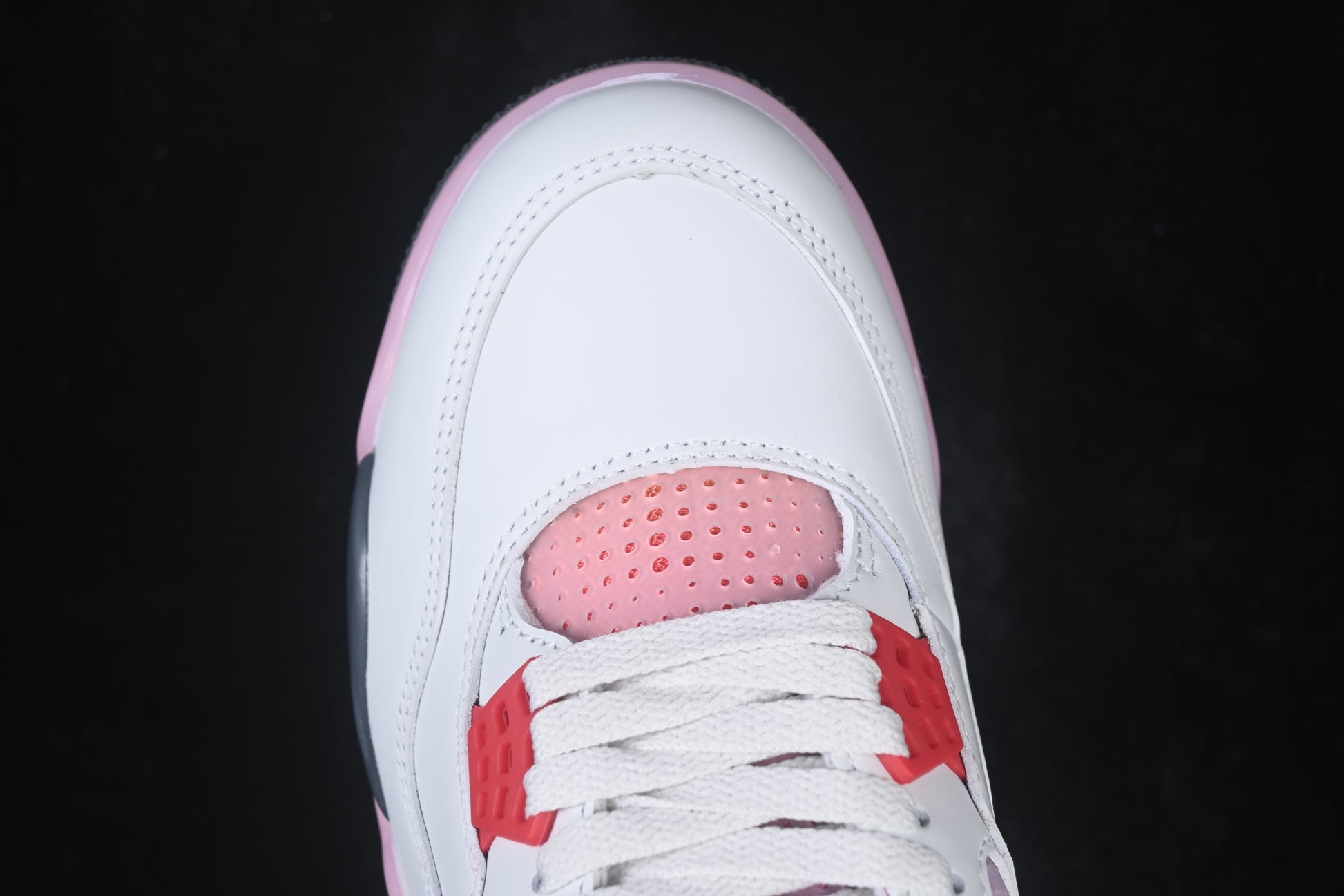 White retro basketball sneaker with pink accents, charcoal support panels, breathable mesh inserts, lace-up closure, and rubber outsole.