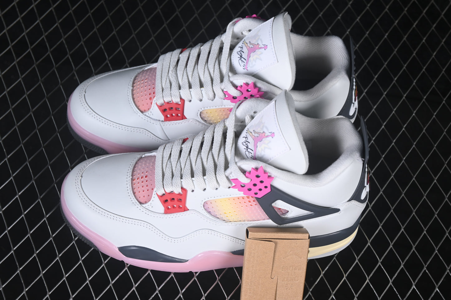 White retro basketball sneaker with pink accents, charcoal support panels, breathable mesh inserts, lace-up closure, and rubber outsole.