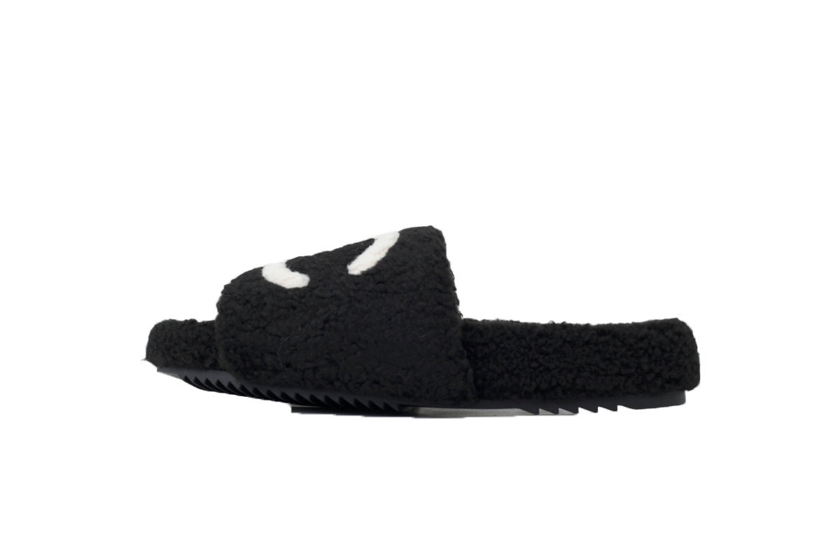 Black slide sandal with white accents on a white background
