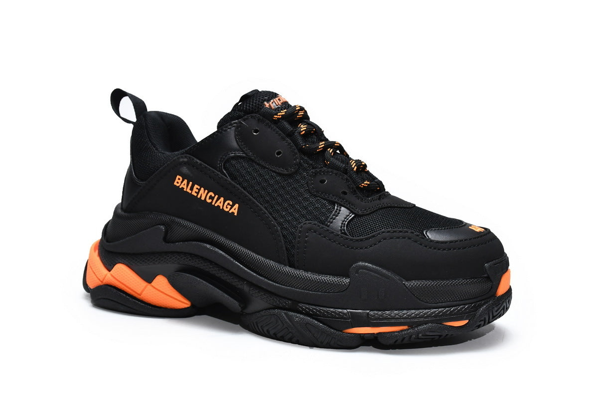 Black  sneaker with orange accents on a white background
