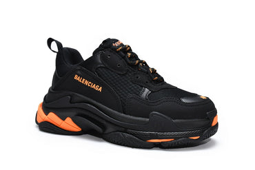Black  sneaker with orange accents on a white background
