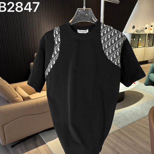 Black t-shirt with patterned shoulder straps on a hanger against a living room background