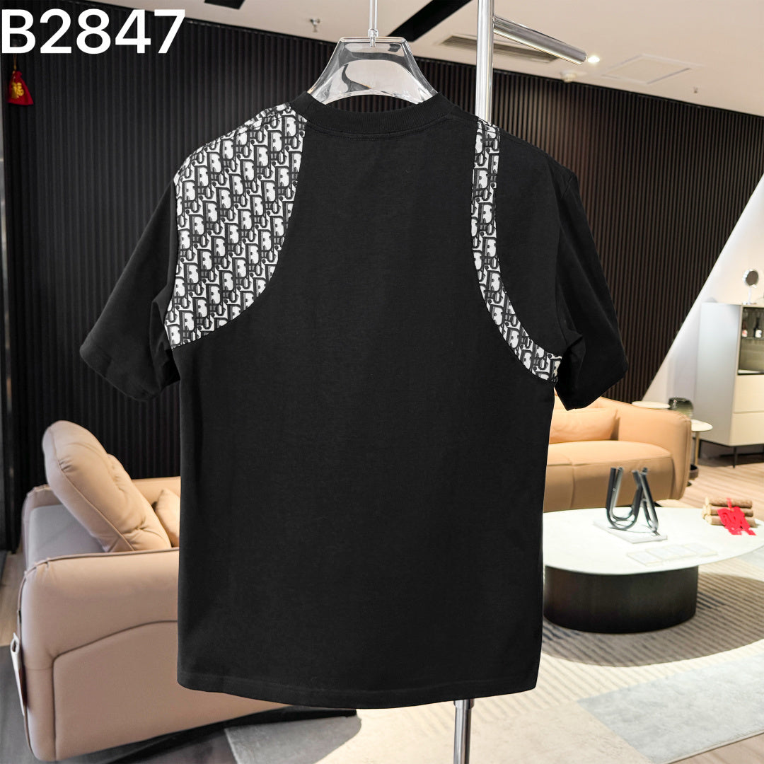 Black dress with patterned sleeves on a hanger in a room with furniture.