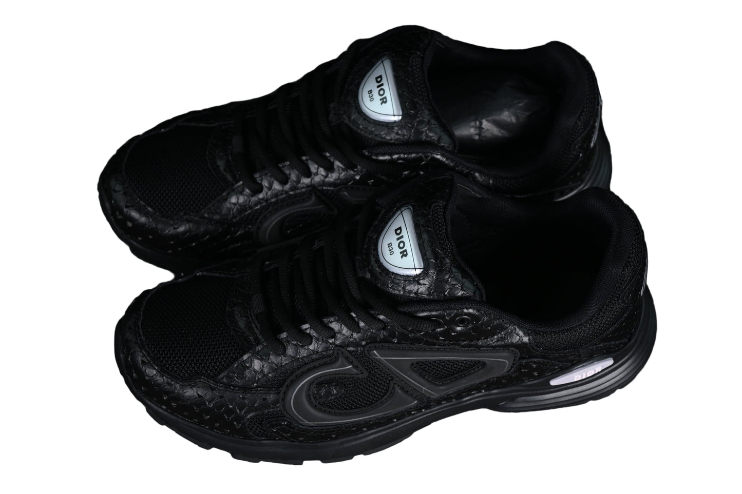 Black sneakers with 'gra[hic on a black grid background