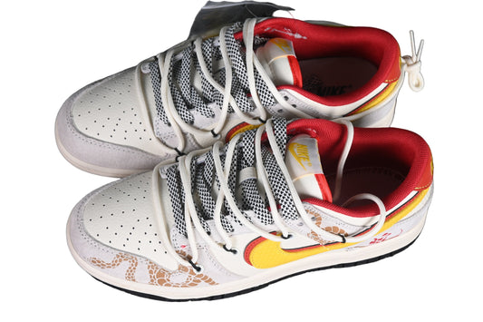 White sneakers with red and yellow accents on a black grid background