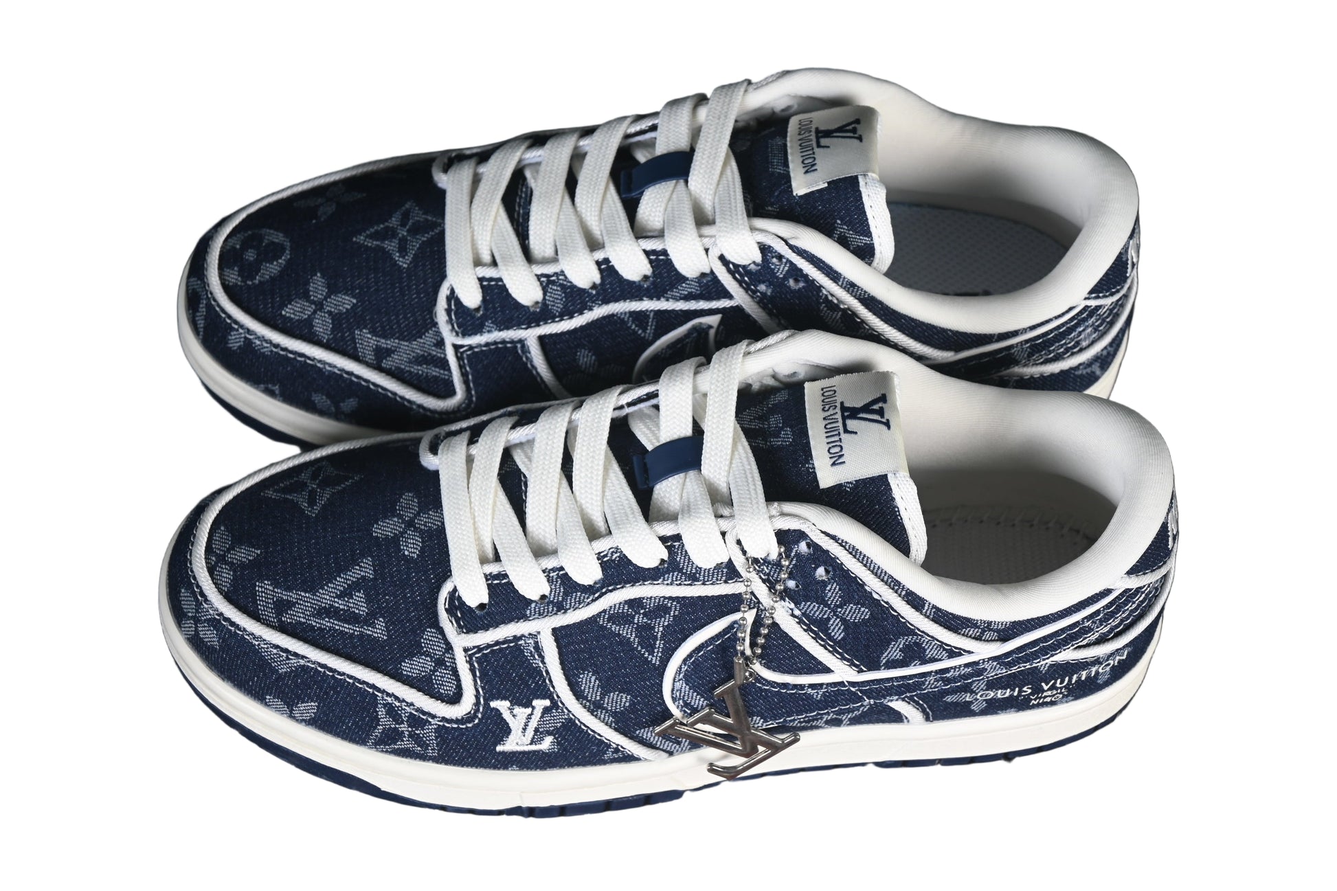 Pair of blue sneakers with white laces on a black mesh background