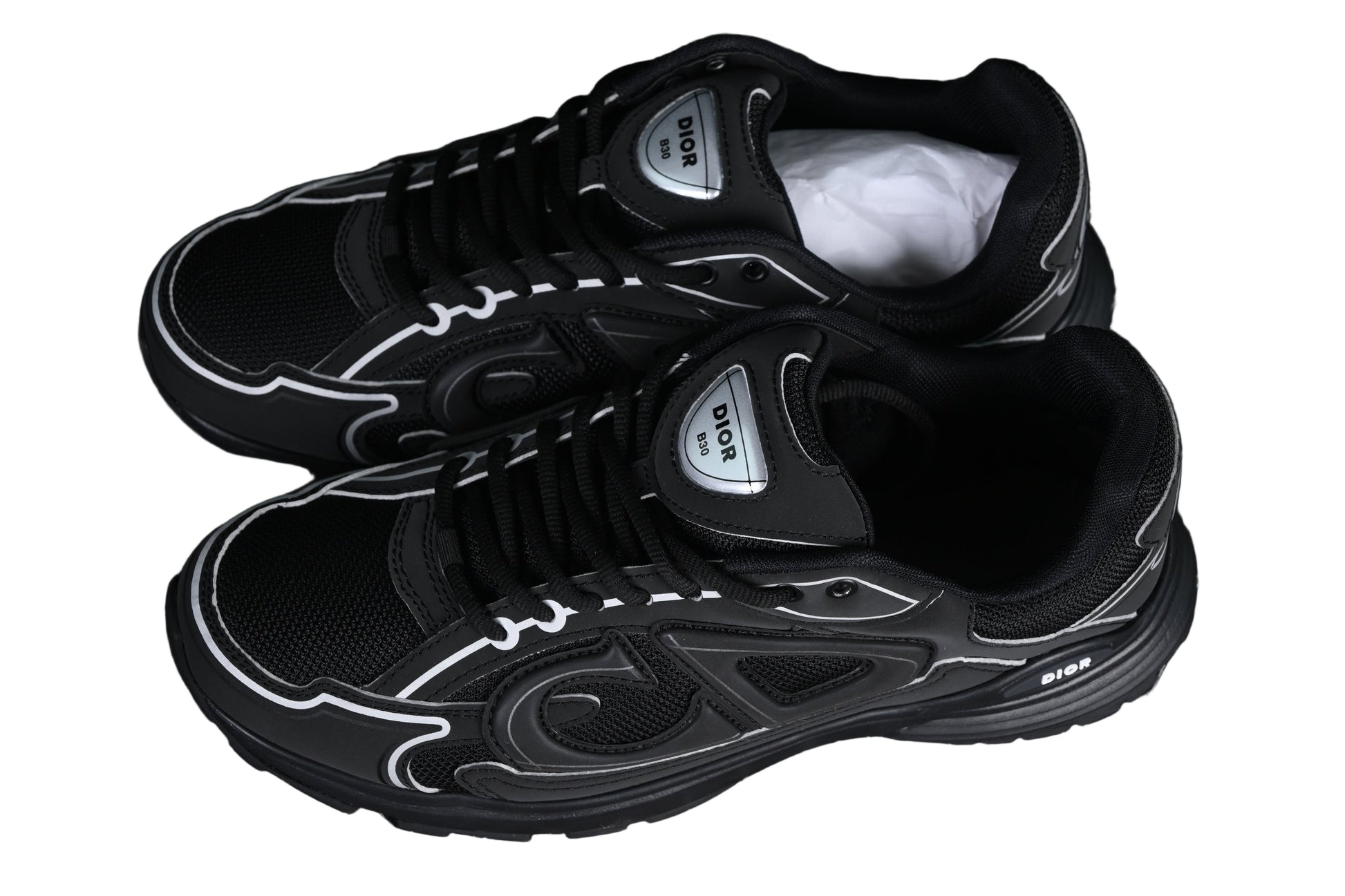 Black sneakers with white accents on a black grid background