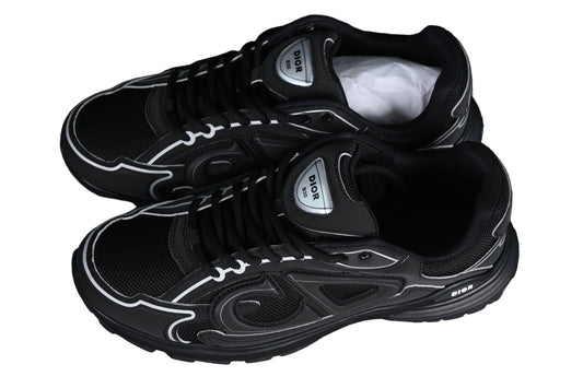 Black sneakers with white accents on a black grid background