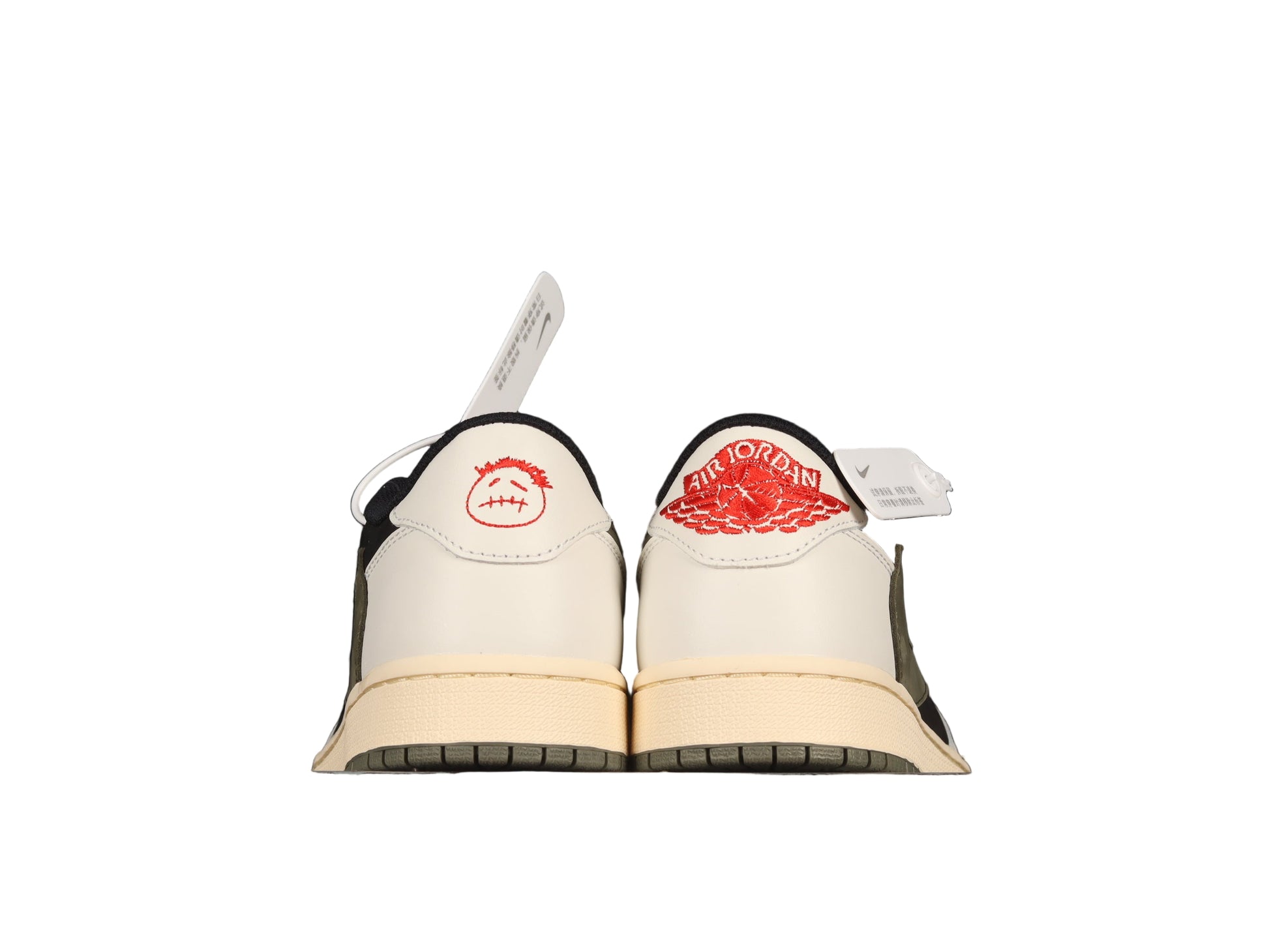 Pair of beige shoes with black soles and red graphic on a white background