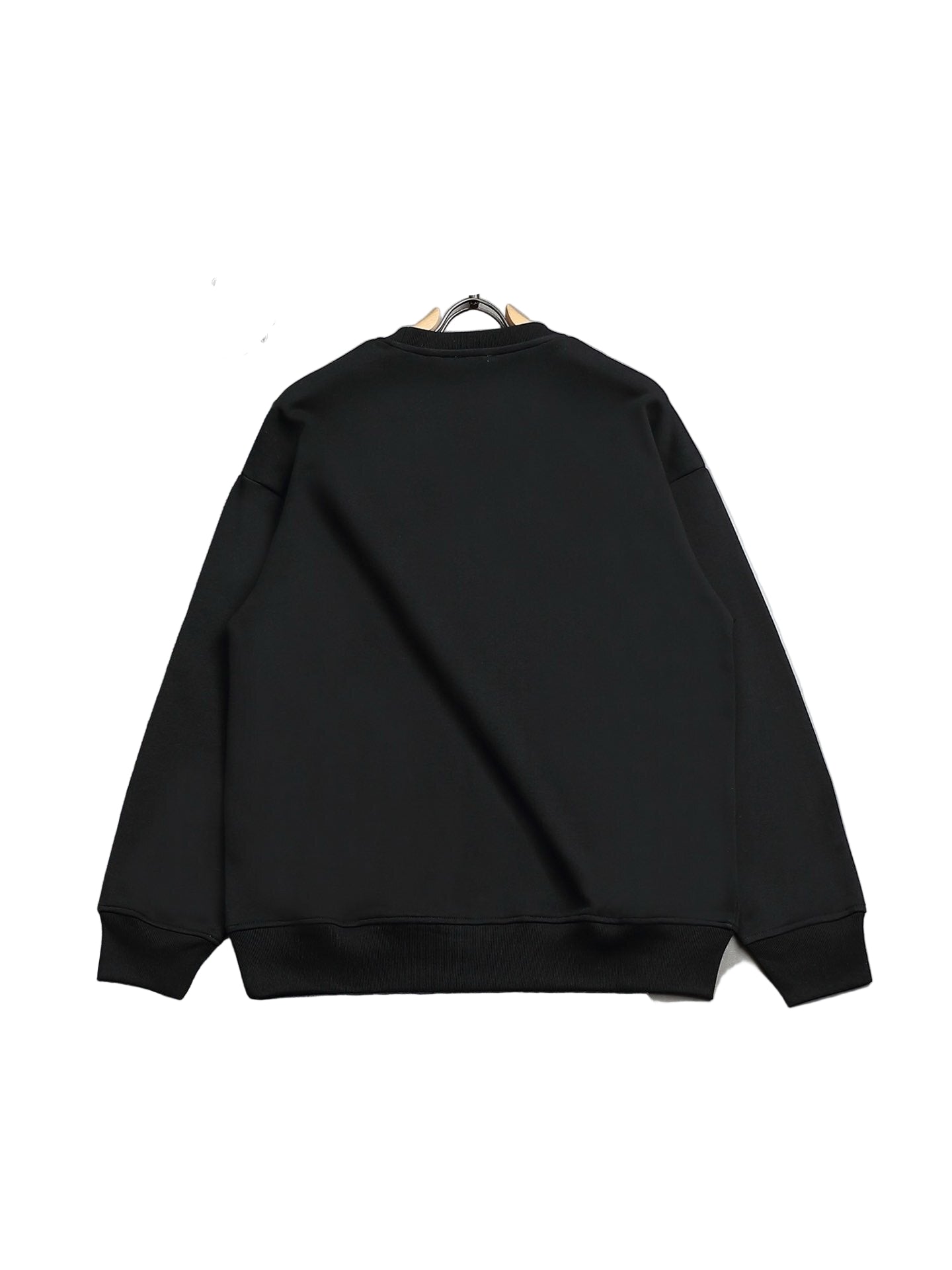 Black sweatshirt on a hanger against a gray floor background