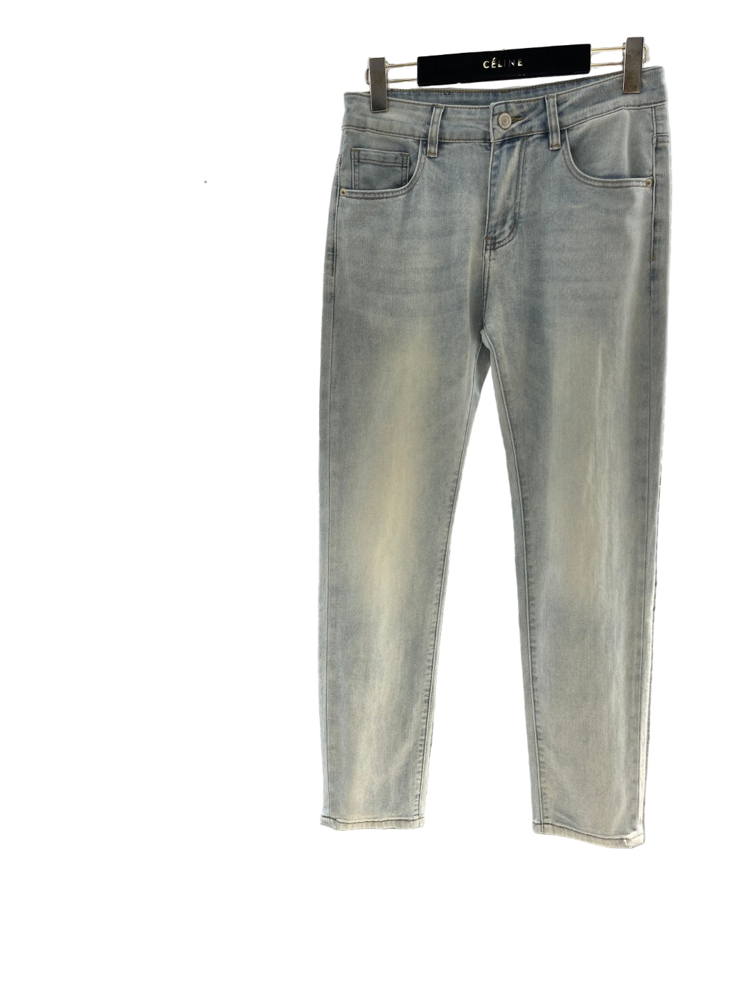 Light gray jeans hanging on a rack with a blurred background