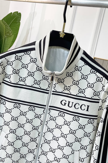  zip-up jacket featuring the brand's signature GG monogram pattern in black on a white base, hanging on a black hanger with a gold-tone hook.