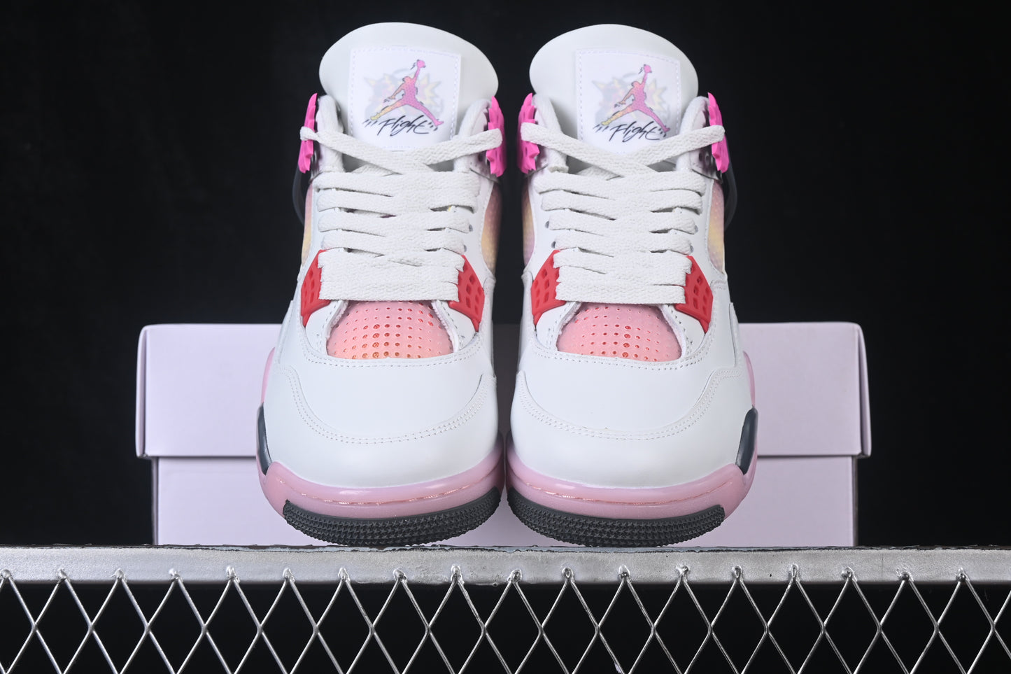 White retro basketball sneaker with pink accents, charcoal support panels, breathable mesh inserts, lace-up closure, and rubber outsole.